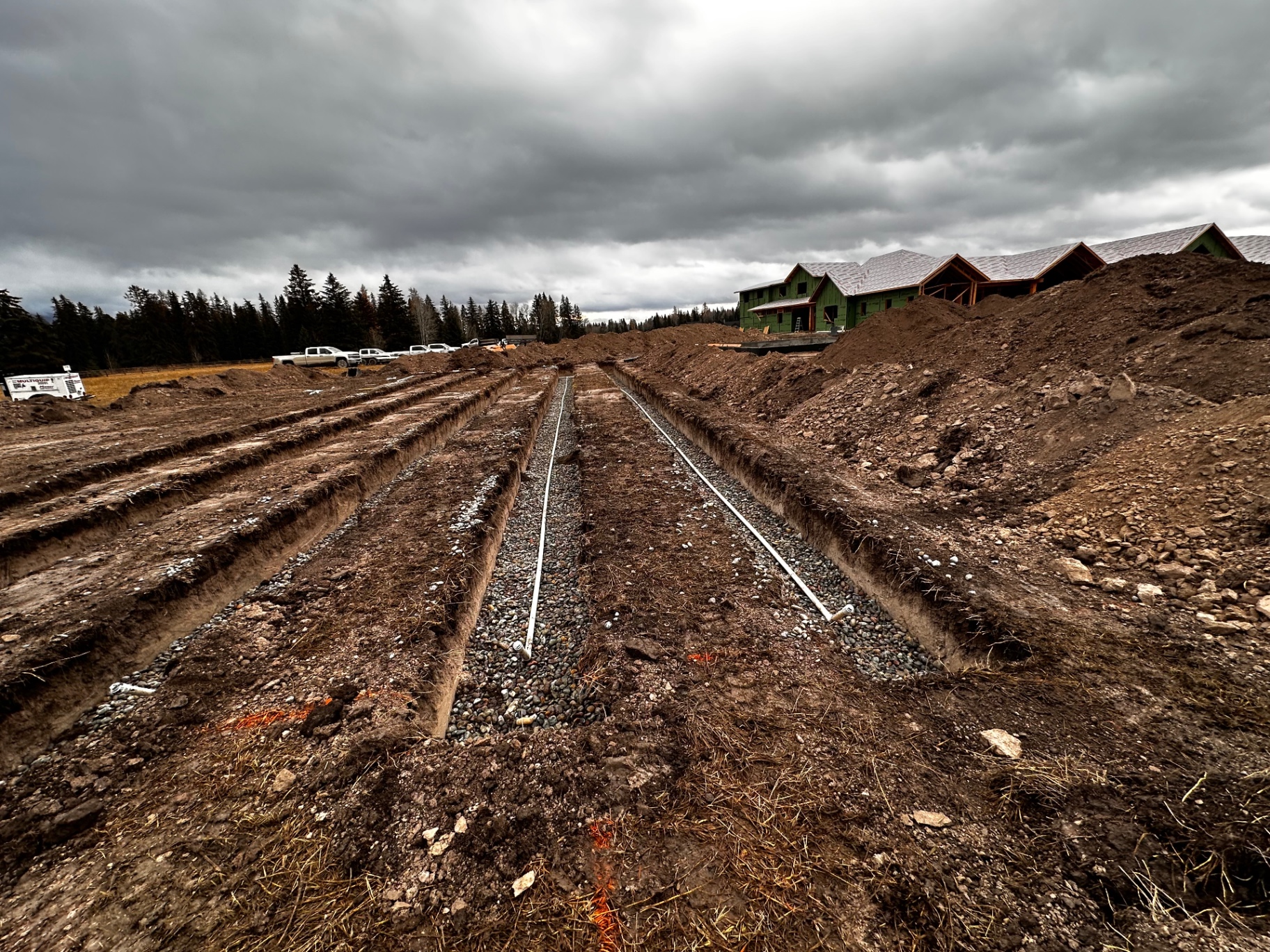Parallel drainage trenches with gravel bedding and perforated pipe