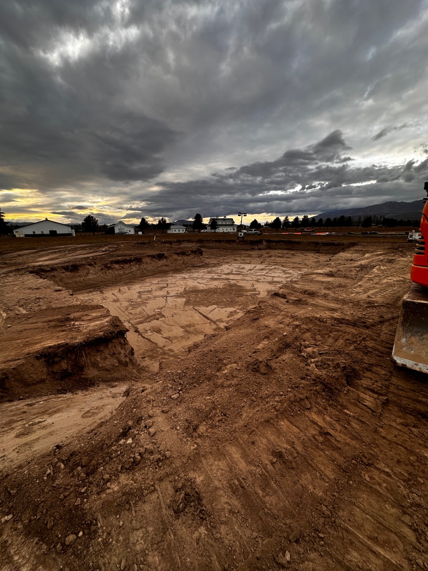 Foundation dig at sunset with stormy sky over the Flathead Valley