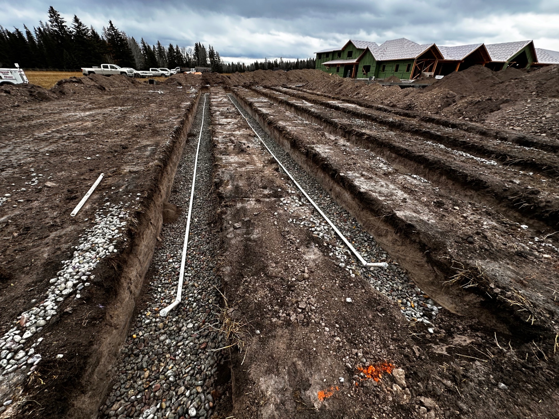 Perimeter drain trenches with gravel bedding around new construction